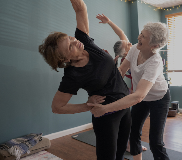 Jen adjusting a standing side stretch.